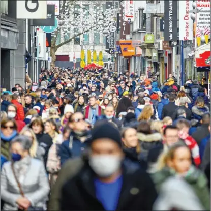  ?? SASCHA SCHUERMANN / GETTY IMAGES ?? A street in Cologne, Germany, is packed on Feb 19 as cases of the Omicron variant of the coronaviru­s were reported in the city.