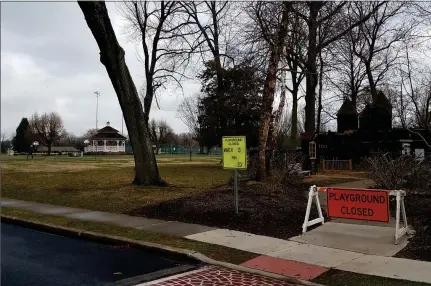  ?? DAN SOKIL - MEDIANEWS GROUP ?? Signs posted next to the playground at Upper Gwynedd’s Parkside place complex indicate that the playground will be closed indefinite­ly, as a jogger keeps pace on a trail running between the playground and the taped-off park pavilion.