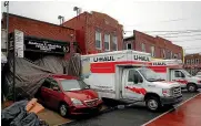  ?? AP ?? Rental trucks and a hearse parked outside Andrew T. Cleckley Funeral Home yesterday in the Brooklyn borough of New York. Police were called to the funeral home after it resorted to storing dozens of bodies on ice in rented trucks.