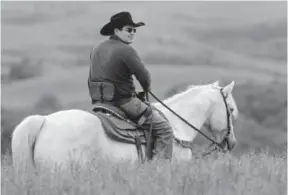  ?? Jay Pickthorn, Argus Leader ?? South Dakota state Sen. Billie Sutton rides a horse on his family’s farm in Gregory County. Sutton is paralyzed from the waist down from a 2007 rodeo accident and uses a special saddle with straps to hold him in without the use of his legs to grip the horse’s side.