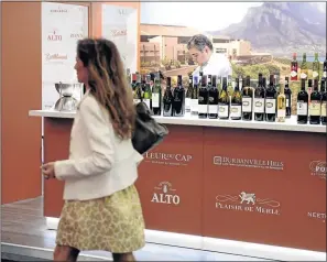  ?? PHOTO: JEAN-PIERRE MULLER/ AFP ?? BOTTLED LUXURY: A woman walks past a South African wine producer ’ s stand at the Vinexpo, the world's biggest wine fair, in Bordeaux