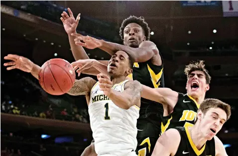  ?? AP Photo/Mary Altaffer ?? ■ Iowa forward Tyler Cook, second from left, forward Luka Garza, second from right, and forward Nicholas Baer, right, stop Michigan guard Charles Matthews (1) from scoring a basket in the second round of the Big Ten conference tournament Thursday at...