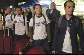  ?? ASSOCIATED PRESS ?? Thai nationals walk to a bus Wednesday as they leave the Shamir Hospital in Ramle, Israel, on their way back to Thailand, after being released from Hamas custody.