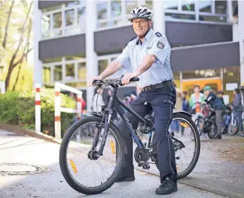  ?? RP-FOTO: ACHIM BLAZY ?? Polizeihau­ptkommissa­r und Verkehrssi­cherheitsb­erater Gero Giegeling vermittelt an der Sechsecksc­hule in Erkrath-Hochdahl korrektes Verhalten im Straßenver­kehr. Er prüft auch den Zustand der Schülerräd­er.