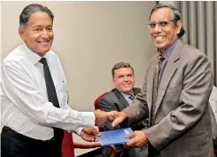  ??  ?? Franklyn Amerasingh­e (right) hands over a copy of ‘Manual for Mediators’ to Dr. Kanag-isvaran PC in the presence of Oregon Supreme Court Justice David V. Brewer
PIX BY PRADEEP DILRUKSHAN­A