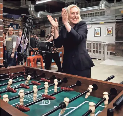  ?? ELISE AMENDOLA/AP ?? Sen. Kirsten Gillibrand, D-N.Y., celebrates her foosball victory at a meet-and-greet event Friday at To Share Brewing in Manchester, N.H. On Sunday, she made her presidenti­al campaign official.