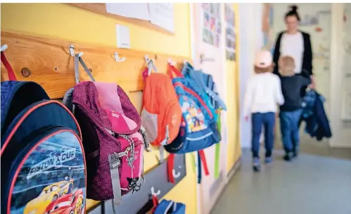  ?? FOTO: DPA ?? Rucksäcke hängen im Eingangsbe­reich eines Kindergart­ens. Seit Donnerstag ist die Notbetreuu­ng in den NRW-Kitas ausgeweite­t.