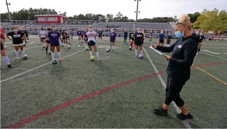  ?? STuART CAHiLL pHOTOs / HeRALd sTAFF ?? START THE SEASON: Hingham girls soccer coach Sarah Dacey gives instructio­ns during the first day of practice. Below, Ava Maguire goes through a drill during practice Friday.