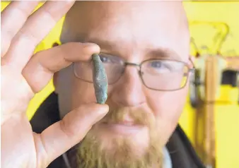  ?? GREG SORBER/JOURNAL ?? Matthew Barbour, regional director of New Mexico Historic Sites, holds a copper crossbow arrow point found at the Coronado Historic Site.