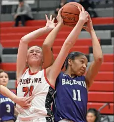  ?? ?? Peters Township's Gemma Walker fights for a rebound with Baldwin’s Janelle Norman.