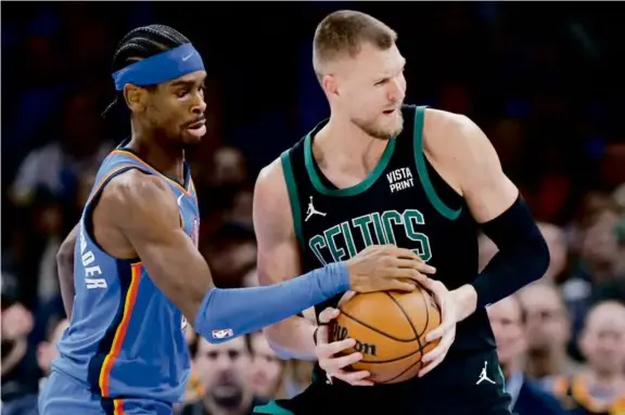  ?? NATE BILLINGS/ASSOCIATED PRESS ?? Kristaps Porzingis, who scored a team-high 34 points in 35 minutes, is harassed by Thunder guard Shai Gilgeous-Alexander.