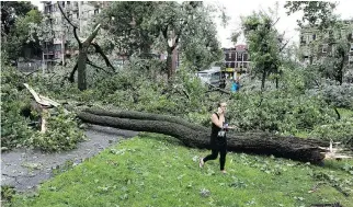  ?? ALLEN McINNIS ?? People survey the damage after the storm ripped through Notre-Dame-de-Grâce Park on Tuesday. Urgences-Santé said the storm caused two collisions, both of which resulted in minor injuries.