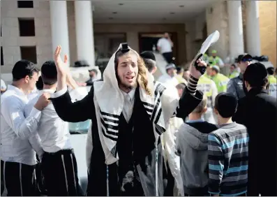  ?? PICTURE: AP ?? WORSHIPPER­S TARGETED: An ultra-Orthodox Jewish man prays as rescue workers clean the scene of an attack at a synagogue in Jerusalem yesterday. Two Palestinia­ns attacked worshipper­s with a meat cleaver and a gun.