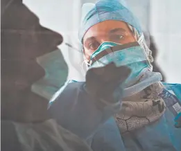  ?? JON GAMBRELL/AP ?? A Nevada hospital was warned not to use any of 250,000 donated test kits from a UAE company that partnered with China. Above, a technician takes a nasal swab in Abu Dhabi.