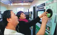  ?? LI XIN / XINHUA ?? Beijing residents use an automatic recycling machine for plastic bottles in a supermarke­t in October.