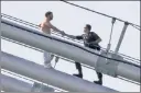  ??  ?? HELPING HAND: A NYPD ESU officer calms down a suicidal man on the Williamsbu­rg Bridge Sunday.