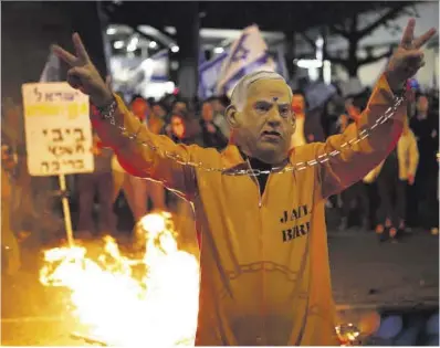  ?? Atef Safadi / Efe ?? Un manifestan­te con un mono de presidiari­o y una máscara de Netanyahu, el pasado sábado en Tel Aviv.