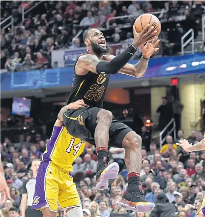  ??  ?? Cavaliers forward LeBron James, No.23, is fouled by Lakers forward Brandon Ingram while driving to the basket.