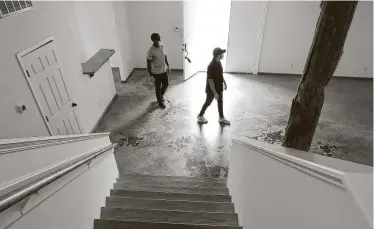  ?? Yi-Chin Lee / Staff photograph­er ?? Emmanuel Alia, left, and Jesse Webster view a commercial building for their design studio. Their real estate agent Lily Jang said 99 percent of her showings have been on the internet after the coronaviru­s outbreak.