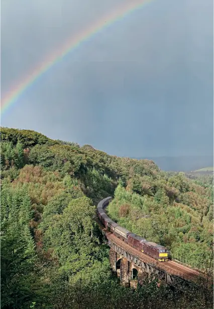  ?? CRAIG MUNDAY ?? Heavy rain and bright sun equals a rainbow at Largin Viaduct (between Bodmin Parkway and Liskeard in Cornwall) as Nos. 33207+37706 head day three of Steam Dreams’ ‘Mayflower’ tour from Penzance to Plymouth, where No. 61306 Mayflower and No. 45596 Bahamas took over for the run back to London Victoria.