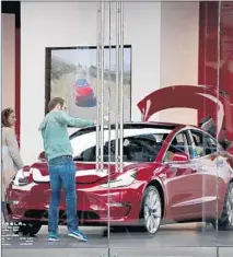  ?? Scott Olson Getty Images ?? A TESLA dealership in Chicago. The automaker had vowed make 5,000 Model 3s a week but produced 9,766 last quarter.