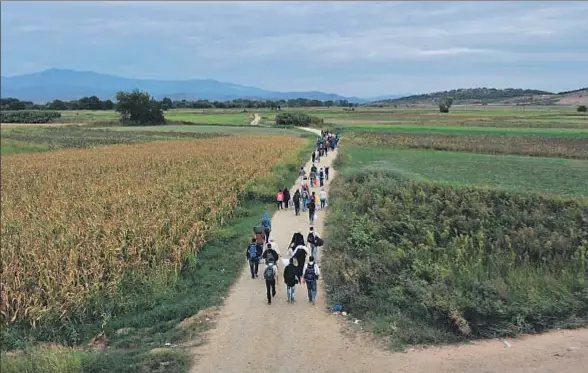  ?? SAKIS MITROLIDIS / AFP ?? Migrantes y refugiados andando ayer cerca de la frontera entre Grecia y Macedonia
