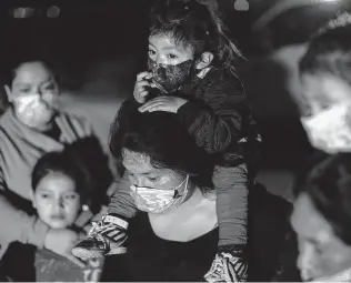  ?? Dario Lopez-MIlls / Associated Press ?? Families from Guatemala wait at a Border Patrol site in March. Slowing immigratio­n would entail supporting Northern Triangle government­s, and making economic and educationa­l investment­s.