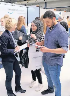  ?? RP-FOTO: OLAF STASCHIK ?? Sarah Marohn (l.) von Denke Zahnmedizi­n berät die syrischen Geschwiste­r Rajaa und Mohammed.