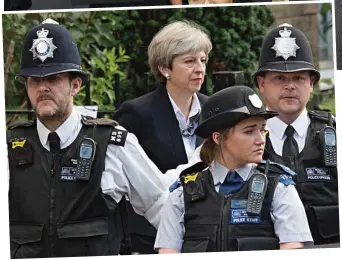  ??  ?? Protection: Police escort Theresa May outside St Clements church yesterday
