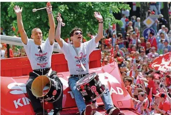  ?? FOTO: WEISSBROD/DPA ?? Martin Wagner (links) und Ciriaco Sforza sitzen auf dem Dach eines Trucks, der die Lauterer Mannschaft durch die Innenstadt fährt. Fast 100 000 Fußball-Fans feiern mit ihren Helden den Meister-Titel.