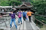  ?? WANG HUABIN / FOR CHINA DAILY ?? Tourists negotiate the Luding Bridge across the Dadu River in Southwest China’s Sichuan province. Associated with the Long March, the site is popular on the red tourism circuit.