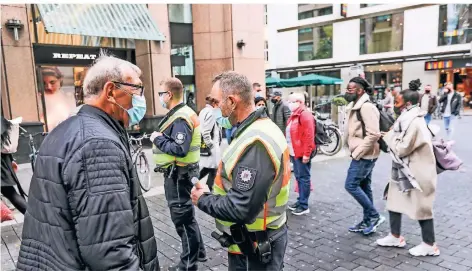  ??  ?? Kontrolle auf der Schadowstr­aße: André Blumenhofe­n (2.v.l.) und Enrico Niepelt (3.v.l.) informiere­n Passanten über die Maskenpfli­cht. Viele Bürger gingen auch