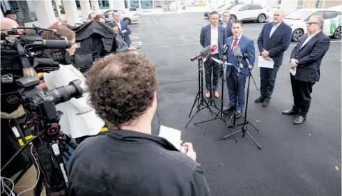  ?? Photo / Dean Purcell ?? The media look on as ministers Michael Wood and James Shaw announce the plan to increase electric vehicle use.