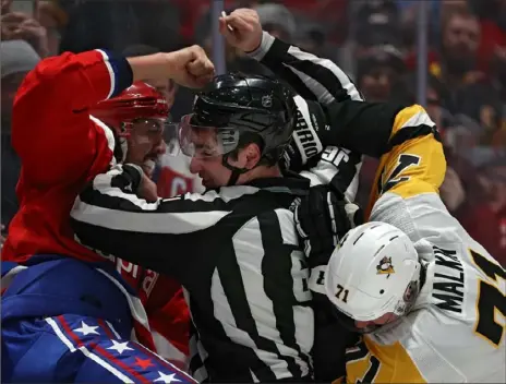  ?? Patrick Smith/Getty Images ?? Above: Linesman James Tobias breaks up a fight between Evgeni Malkin, right, and the Capitals’ Brenden Dillon in the first period Sunday at Capital One Arena in Washington. Left: Capitals left winger Carl Hagelin, right, celebrates his empty-net goal to seal the win as the Penguins’ Patric Hornqvist looks on in the third period. “Overall, we were the better team,” Hornqvist said. “It’s two good teams going at it. It’s a hell of a matchup.”