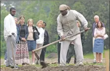  ?? (File Photo/AP/Steve Helber) ?? Historical interprete­r Robert Watson (center) works a field as a group of visitors watches on the Great Hopes Plantation at Colonial Williamsbu­rg in Williamsbu­rg, Va., in 2015. Colonial Williamsbu­rg is an immersive living-history museum where costumed interprete­rs of history reenact scenes and portray figures from that period.