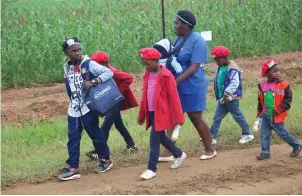  ??  ?? A woman and some children head home after yesterday’s celebratio­ns.