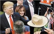  ?? ALEX BRANDON/AP ?? President Donald Trump hands back a signed hat Wednesday as he greets military families with first lady Melania.