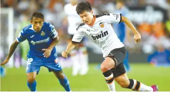  ?? AFP-Yonhap ?? Valencia’s South Korean midfielder Lee Kang-in, right, competes with Getafe’s Uruguayan defender Damian Suarez during the Spanish league football match between Valencia CF and Getafe CF at the Mestalla stadium in Valencia, on Sept. 25.