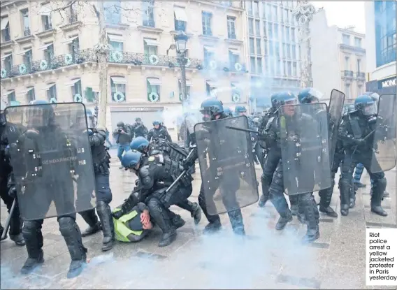  ??  ?? Riot police arrest a yellow jacketed protester in Paris yesterday