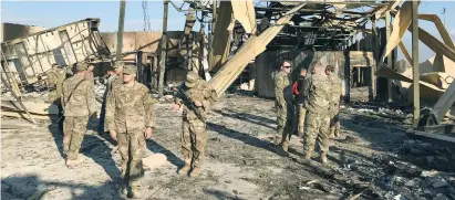  ?? (John Davison/Reuters) ?? US SOLDIERS inspect the site where an Iranian missile struck the Ain al-Asad air base in Iraq’s Anbar province in January.