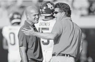  ?? Sue Ogrocki / Associated Press ?? Baylor coach Dave Aranda, left, and Oklahoma State coach Mike Gundy will meet in a Big 12 title game that will be missing both Texas and Oklahoma for the first since 1998.