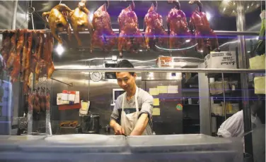  ?? Photos by Michael Macor / The Chronicle ?? A cook works at New Asia restaurant, a site the late activist Rose Pak had long sought for affordable housing. The city will pay $5 million for the property and remake it for housing and the restaurant.