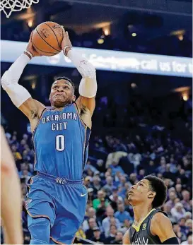  ?? [AP PHOTO] ?? Oklahoma City’s Russell Westbrook, who scored 34 points, dunks over Golden State’s Patrick McCaw during the first half Tuesday in Oakland, Calif.