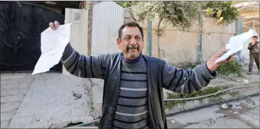  ??  ?? Abu Wissam, whose wife and son were killed by Daesh militants, cries as he holds up the militants’ execution order for his son, east of Mosul, Iraq.