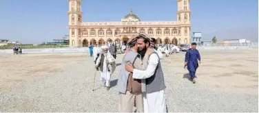  ?? Reuters ?? ↑
People greet each other after offering Eid prayer outside a mosque in Laghman province on Sunday.