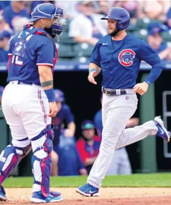  ?? DYLAN BUELL/GETTY IMAGES ?? David Bote trots past Rangers catcher Sandy Leon to score on Sergio Alcantara’s double in the fourth inning of the Cubs’ 9-6 victory Tuesday at Surprise Stadium.