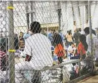  ?? AP ?? People who were taken into custody related to cases of illegal entry into the US, among them children, sit in a cage at a facility in McAllen, Texas.