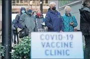  ?? ASSOCIATED PRESS FILE PHOTO] ?? People stand near a sign Jan. 24 as they wait in line to receive the first of two doses of the Pfizer vaccine for COVID-19 at a one-day vaccinatio­n clinic set up in an Amazon facility in Seattle and operated by Virginia Mason Franciscan Health. Scientists say it's still too early to predict the future of the coronaviru­s, but many doubt it will ever go away entirely. [TED S. WARREN/