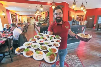  ?? RP-FOTO: HANS-JÜRGEN BAUER ?? Im Layali serviert Restaurant­mitarbeite­r Reboa Salam Abbas mehr als 20 Vorspeisen.