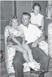  ?? Contribute­d ?? Valarie (Tabor) Alderson sits on her father Raymond’s lap on the ferry to Prince Edward Island in August 1958 while her sister Susan stands over his right shoulder.